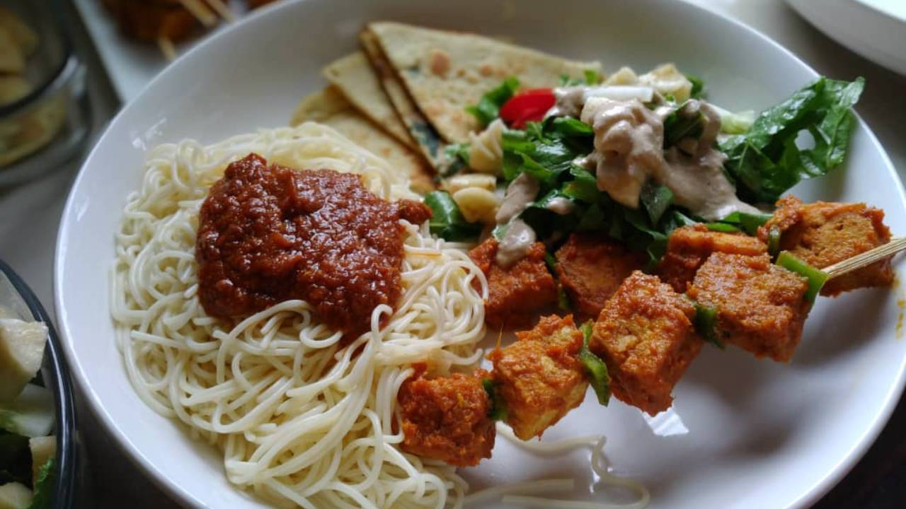 Delicious spread of noodles, skewers, salad, and flatbread